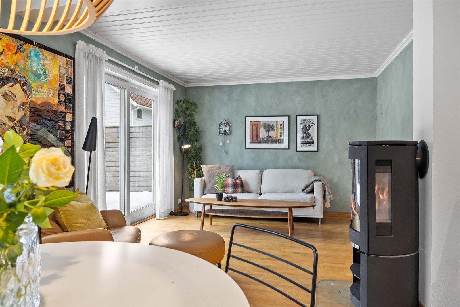 I stuen er det en hyggelig peisovn som er sentralt plassert og danner et naturlig blikkfang i rommet. Den bidrar både med behagelig varme og en lun atmosfære på kjølige dager, og skaper en ekstra følelse av hjemmekos. Galleribilde