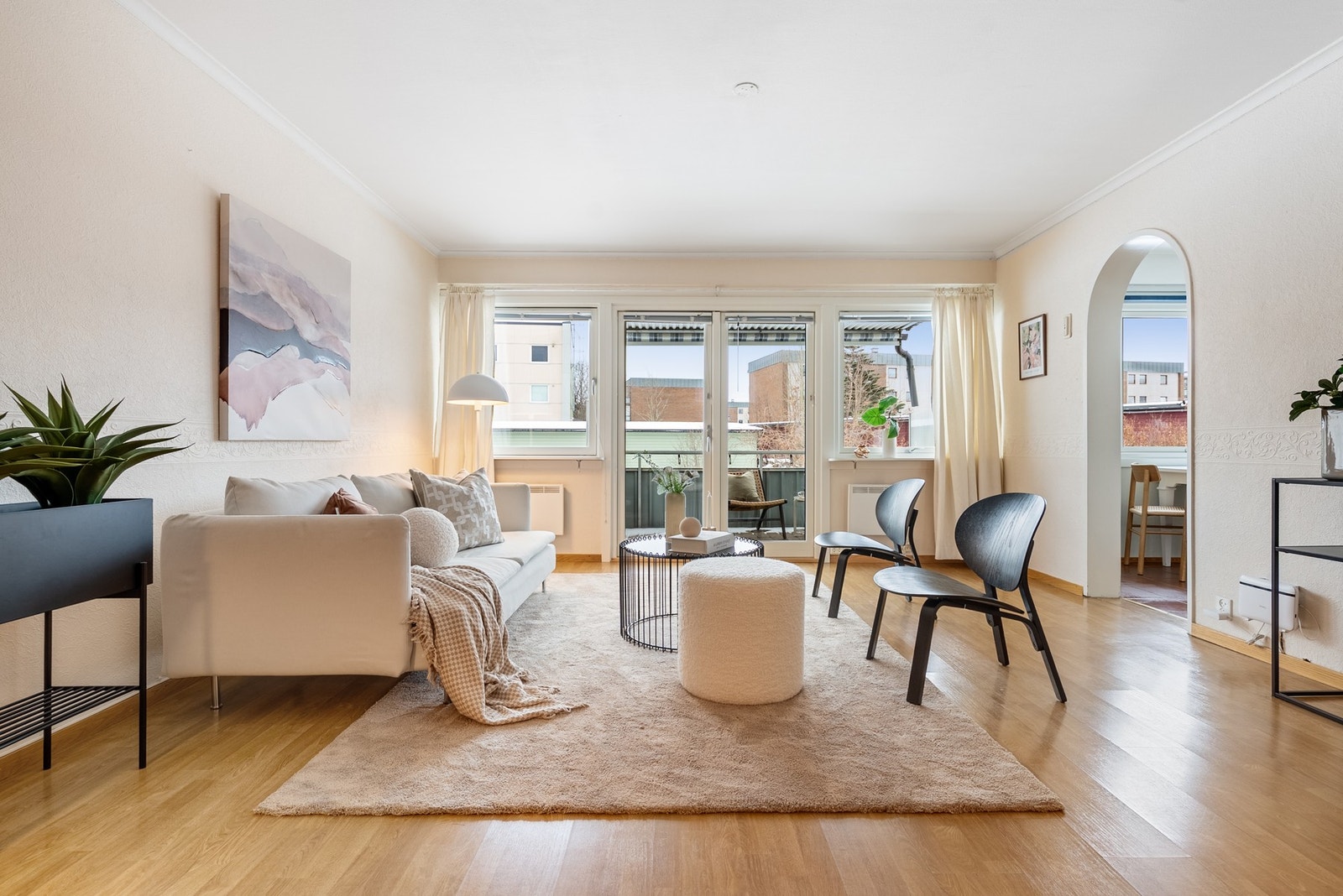 Fra entreen kommer du inn i lys og åpen stue med nøytrale fargevalg og godt lysinnslipp via vinduer mot balkong Galleribilde