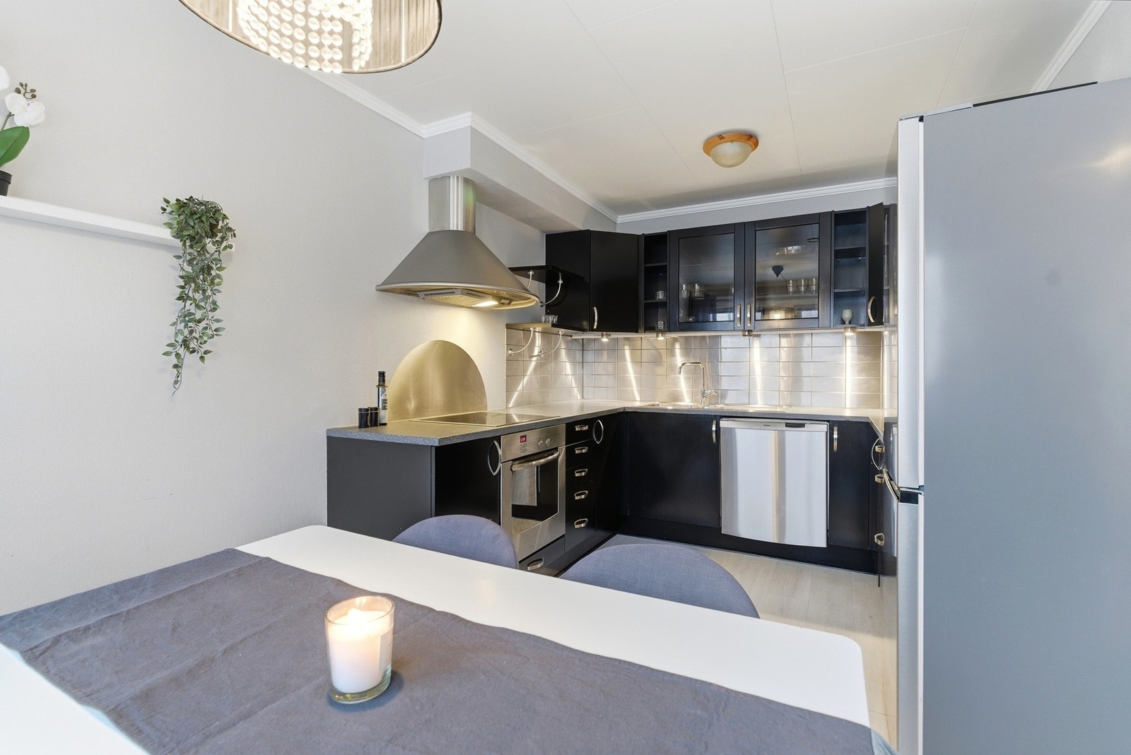 Det er kjøkkeninnredning med sorte slette fronter. Galleribilde