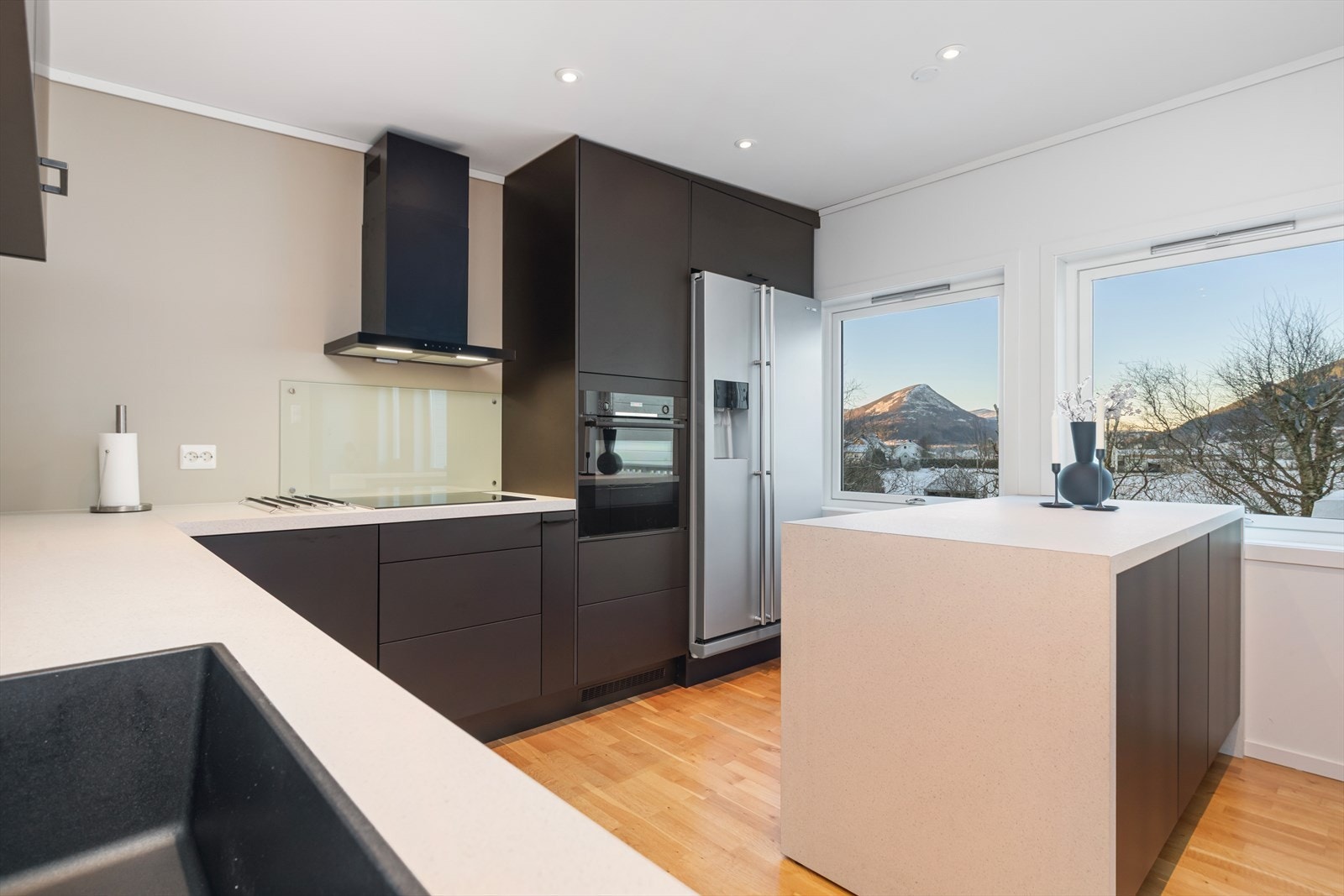 Fint og moderne kjøkken | ny innredning ble satt inn i 2022 | skapfronter i malt utførelse og benkeplater av laminat med underlimt vask og nedfelt platetopp | integrert stekeovn, oppvaskmaskin og utsparing for side-by-side kjøleskap Galleribilde