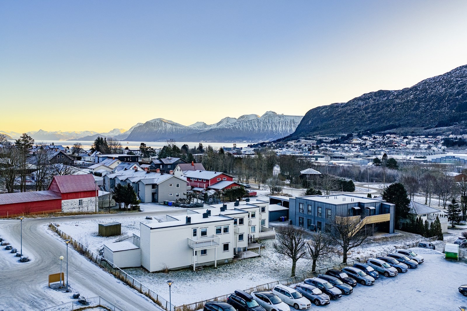 Skrånende, vestvendt fellestomt for sameiet er opparbeidet med treterrasser, belegningsstein og gressarealer | tomtens innkjørsel og parkeringsarealer med toppdekke av asfalt Galleribilde