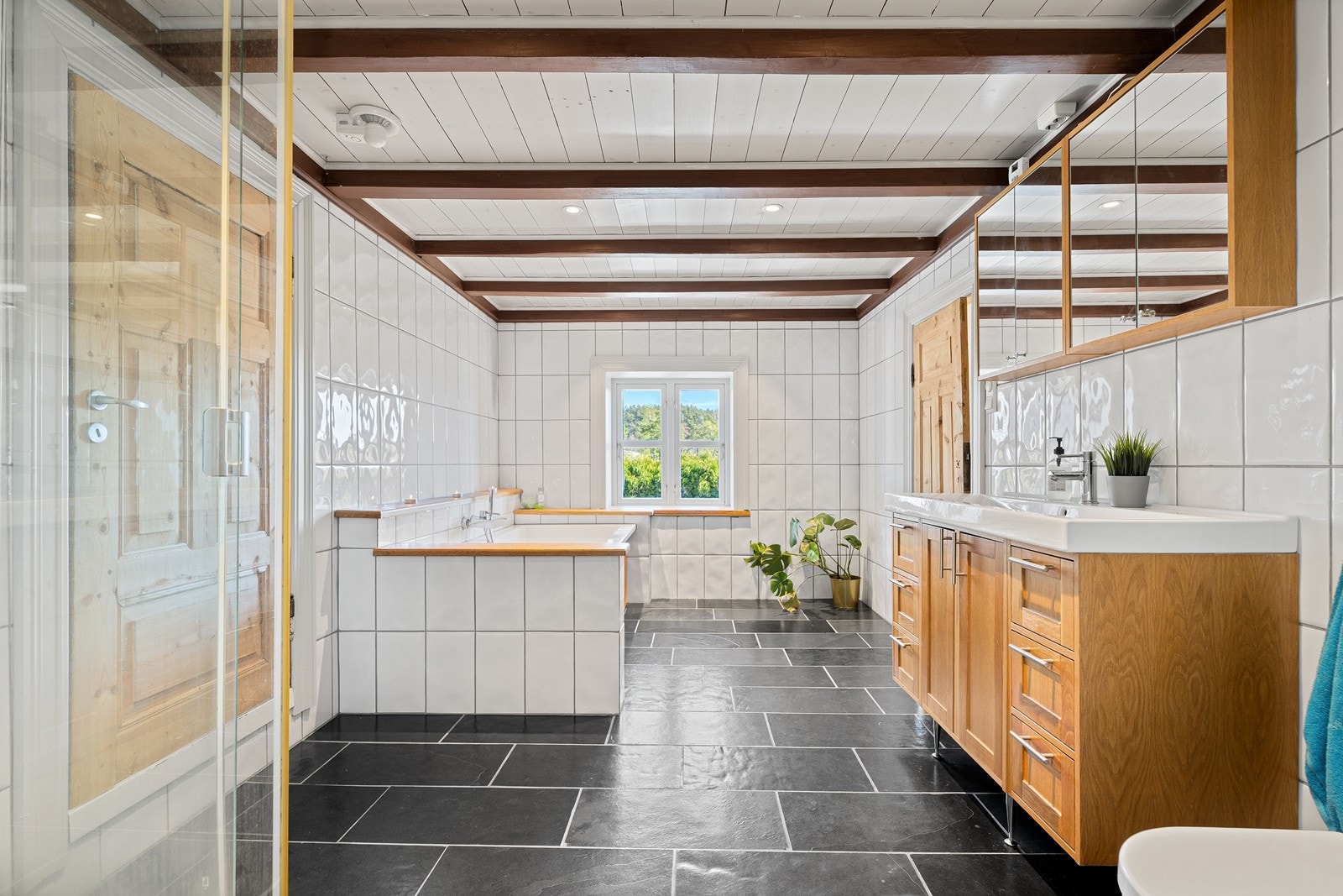 Badet i 2 etg. med varmekabler, badekar, wc, dusjkabinett, servant med skuffer og skap under og overskap. Inngang garderobe til venstre. Galleribilde