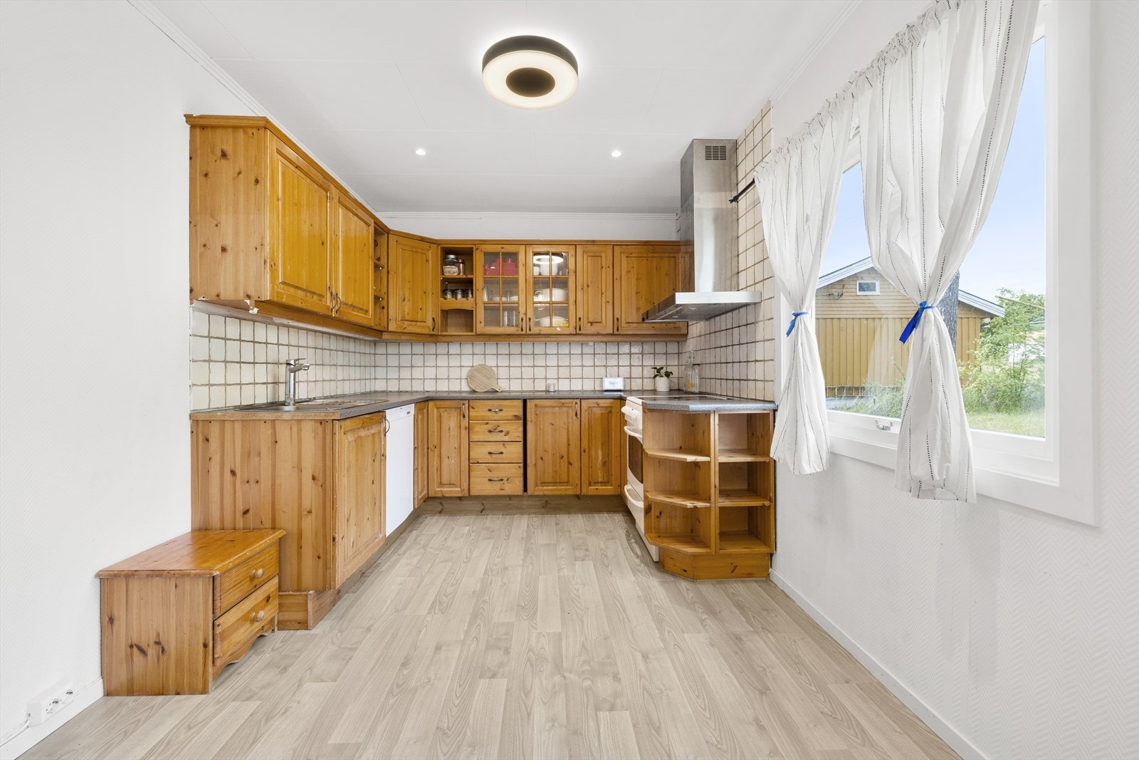 Eldre kjøkken med god plass i over- og underskap. Innredningen kan fint males over, for å gjøre det noe mer moderne. Galleribilde