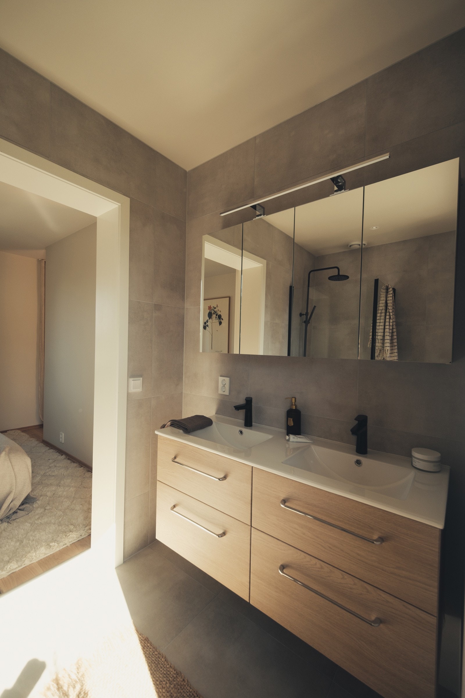 Badet er innredet med 2 nedfelte servanter, veggmontert toalett og dusjvegger/hjørne. Galleribilde