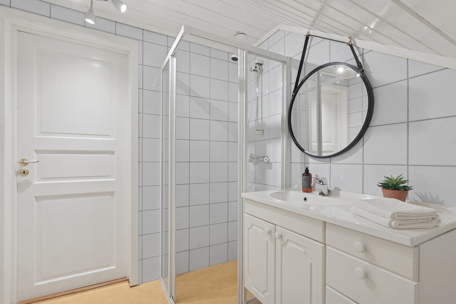 I loftsetasjen har man også et baderom. Badet er fra 90-tallet og er innredet med belegg på gulv og lyse fliser på vegg. Badet er ellers utstyrt med dusjhjørne, toalett og baderomsinnredning med servant. Galleribilde