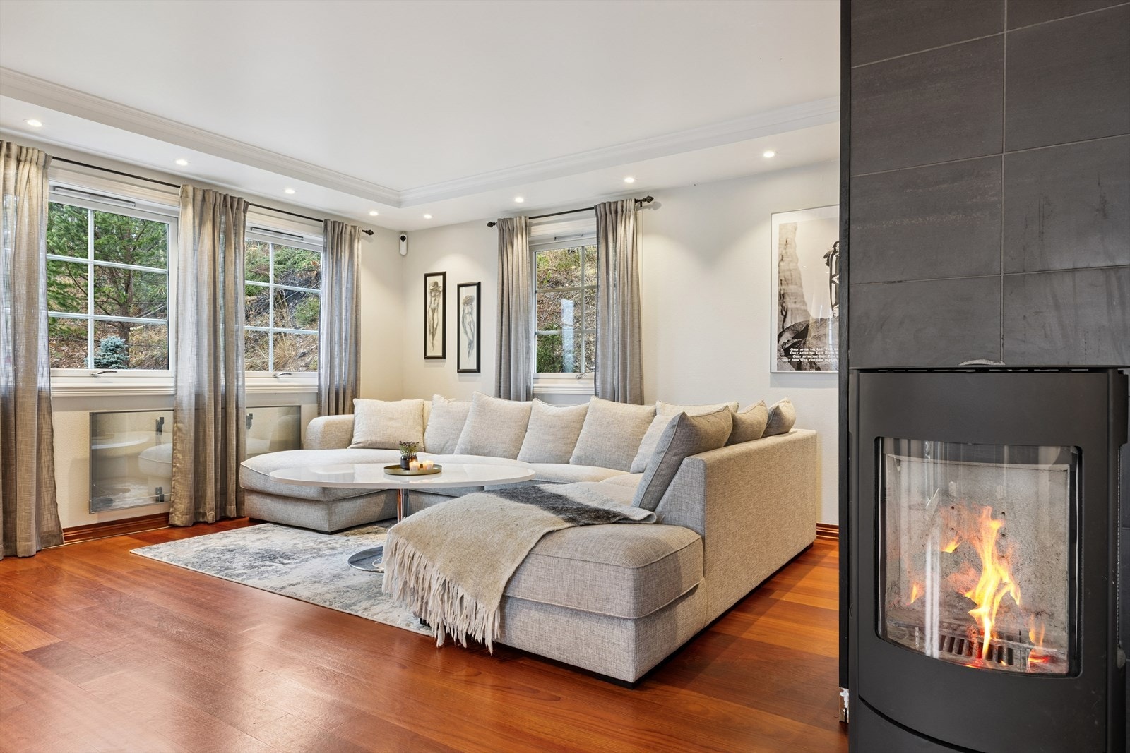 En peisovn gir både varme og hygge på kjølige dager, mens varmepumpen, praktisk plassert i trappegangen, bidrar til energieffektiv oppvarming Galleribilde