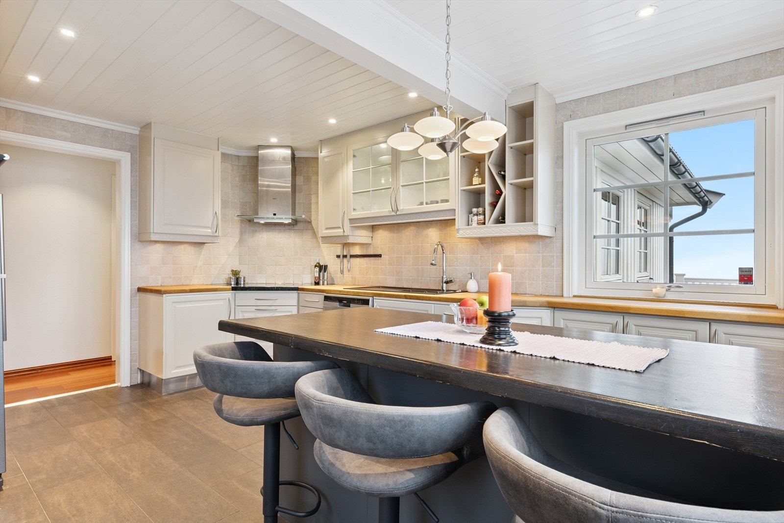 Kjøkkenøya fungerer som ekstra arbeidsbenk og spiseplass Galleribilde