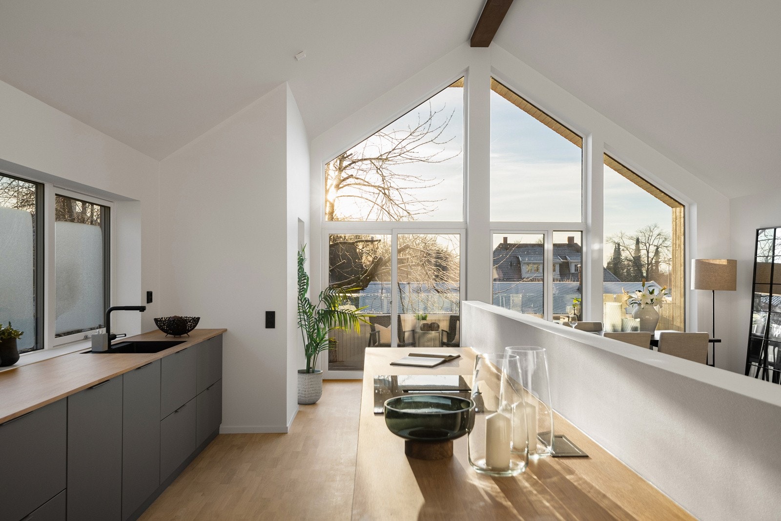 Oppholdsrommet er belyst fra tre himmelretninger som gir mye naturlig dagslys. Veggen bak kjøkkenøya skaper en naturlig avskjerming mot kjøkkenarbeidet, perfekt når man underholder gjester. Galleribilde