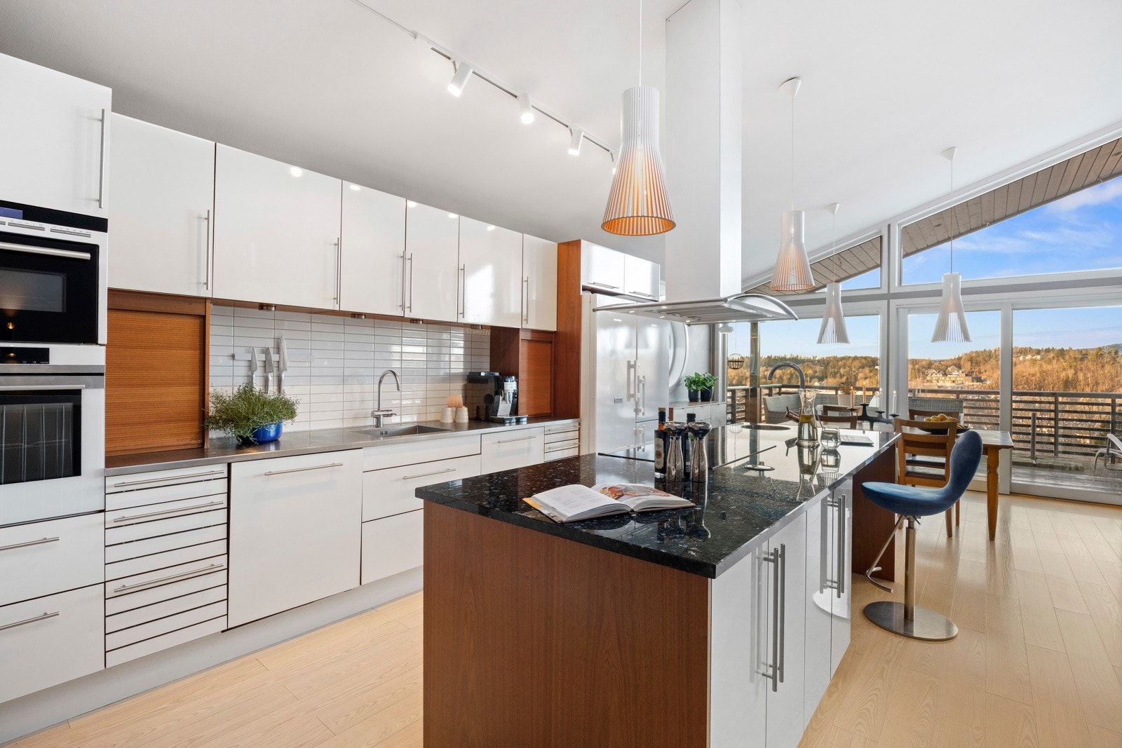 Det er også en sosial kjøkkenøy med benkeplate i stein, nedfelt bred platetopp og takhengt ventilator. Videre er kjøkkenet utstyrt med stort kjøleskap med frysedel, integrert oppvaskmaskin, stekeovn, kombinert steke-og mikrobølgeovn Galleribilde