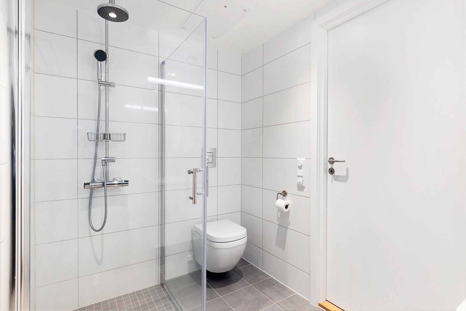 Badet har vegghengt toalett og praktisk dusjhjørne med regnfallsdusj. Galleribilde