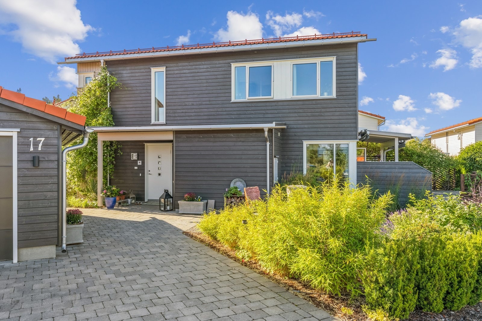 Den steinbelagte gårdsplassen binder hage og inngangsparti sammen. Galleribilde