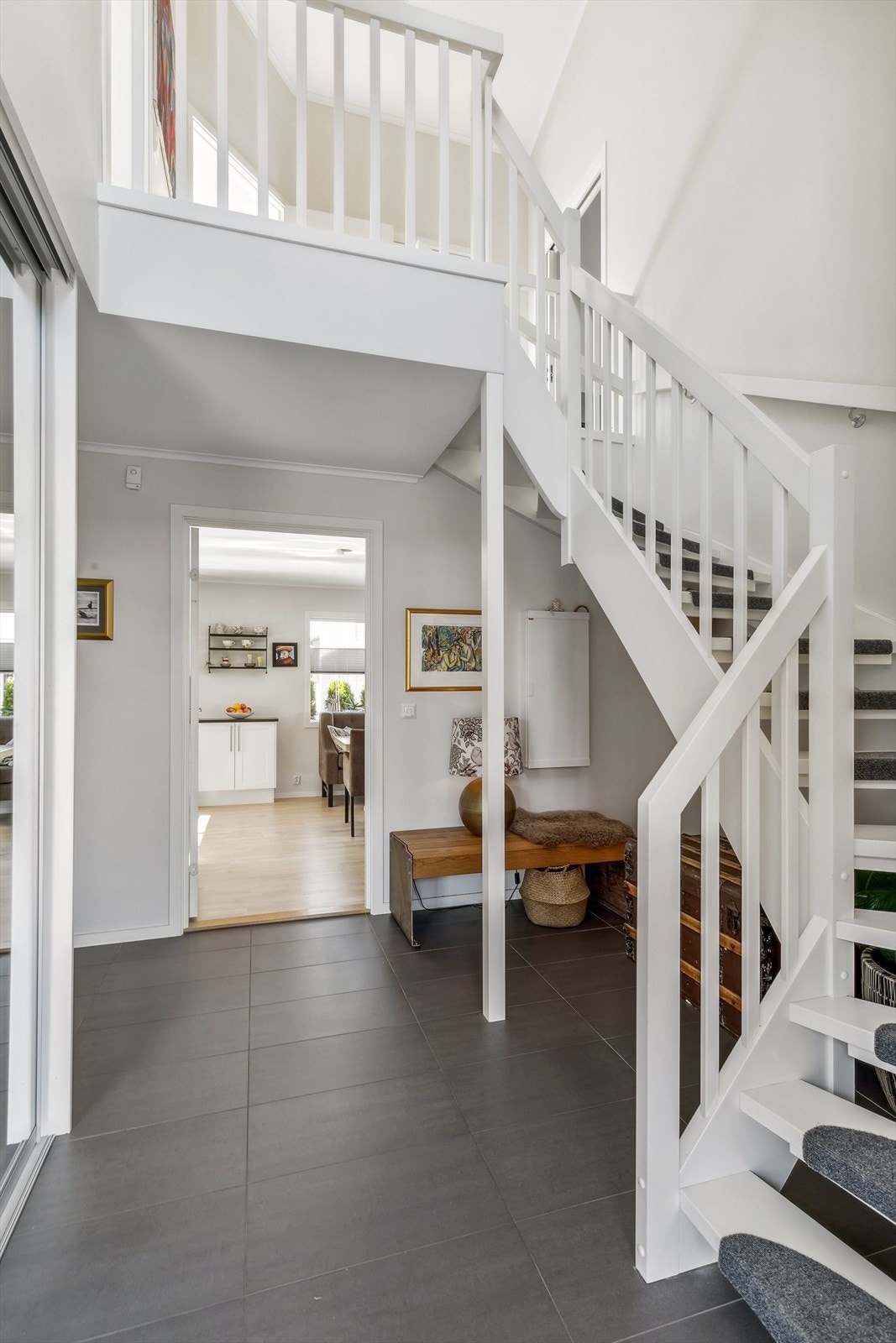 Fra entréen er det adkomst alle rom i 1. etg., som inkluderer stor stue/kjøkken i åpen løsning og bad/vaskerom. Flott trapp til 2.etg. Galleribilde