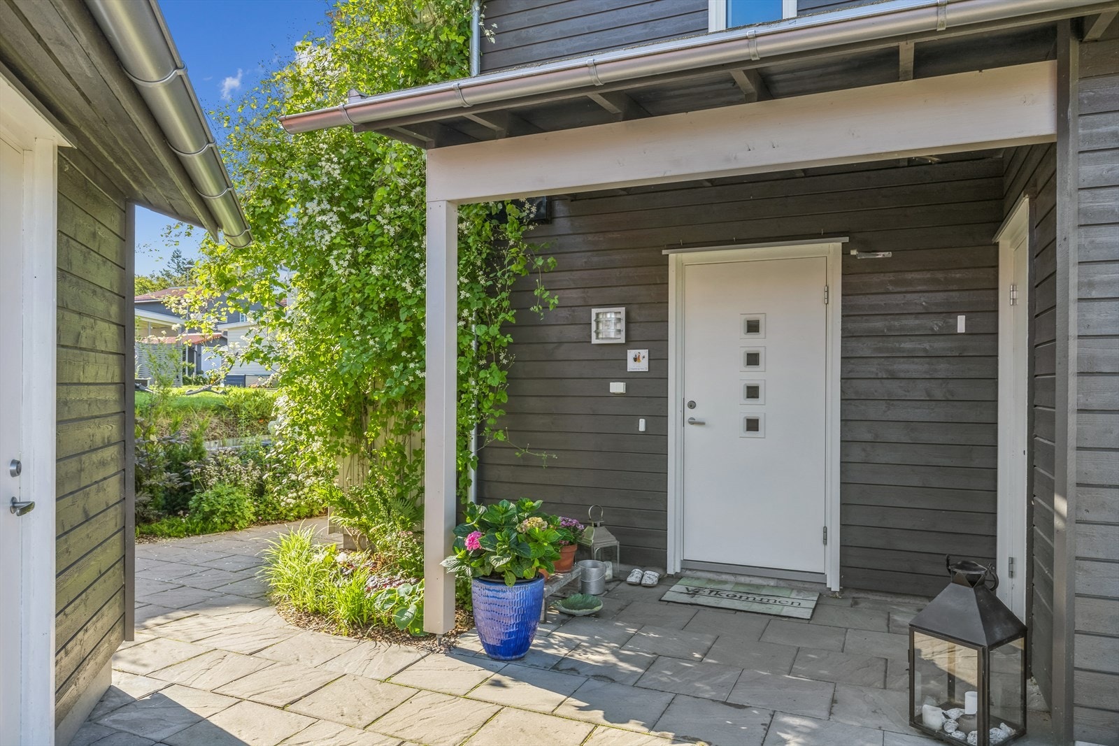 Overbygget inngangsparti. Ved inngangspartiet er det direkte tilknytning til en utvendig bod (høyre), samt lettvinn adkomst til garasjen. Galleribilde