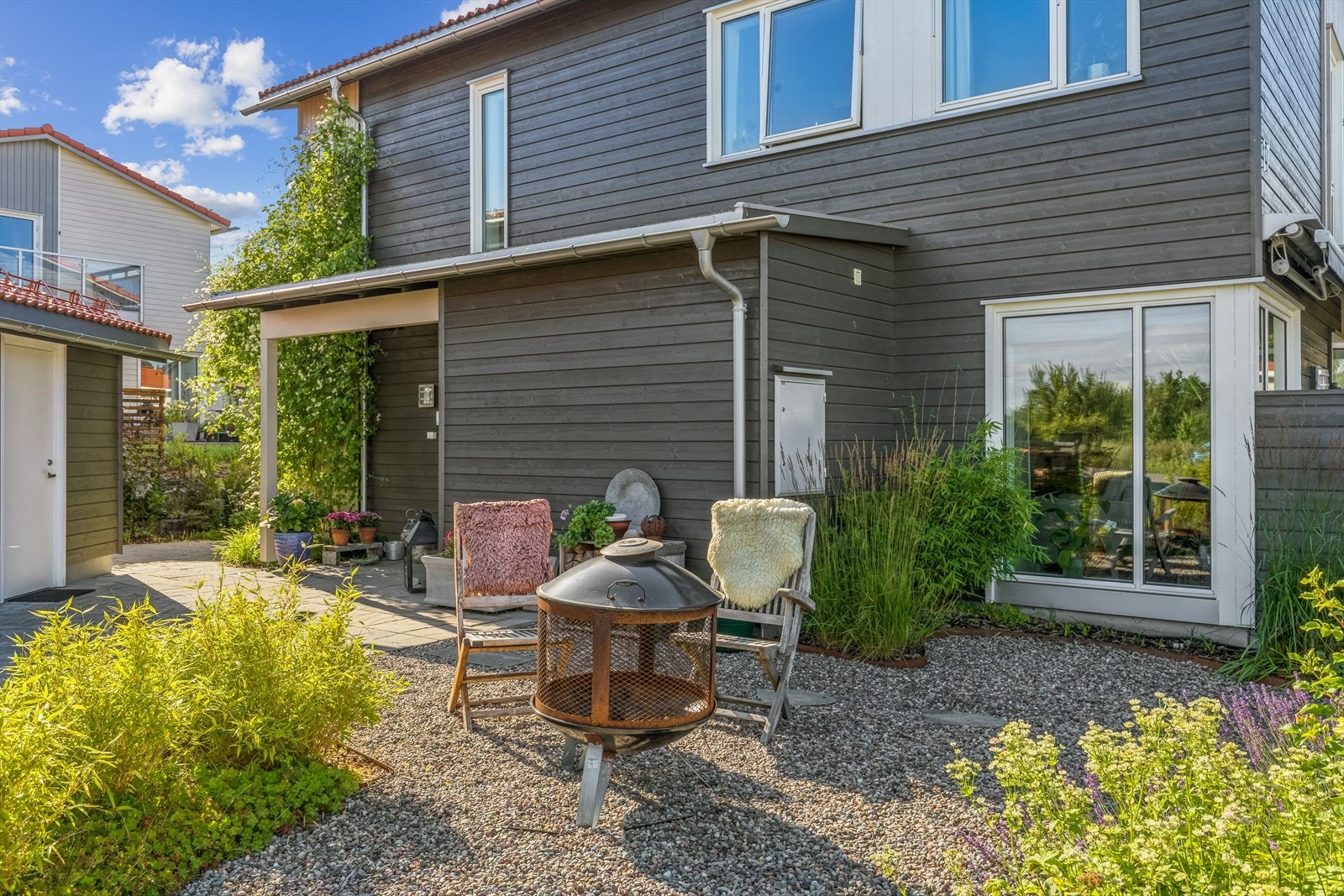 Hver kvadratmeter av tomten er utnyttet til det optimale. Her med bålplass ved inngangspartiet, på hjørnet mot terrassen. Galleribilde