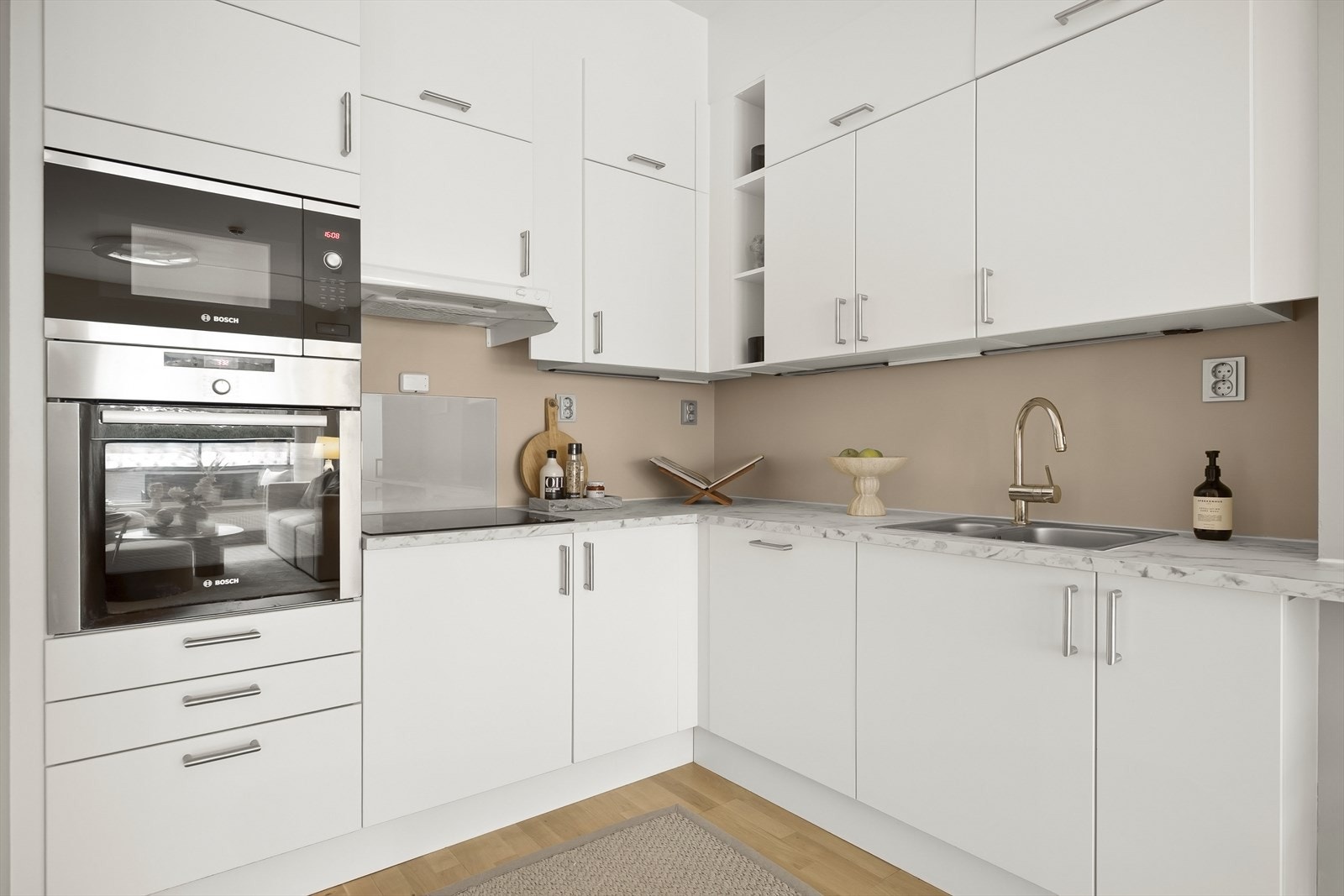 Tidsriktig innredning med hvite, glatte fronter og nyere benkeplate i laminat. Galleribilde