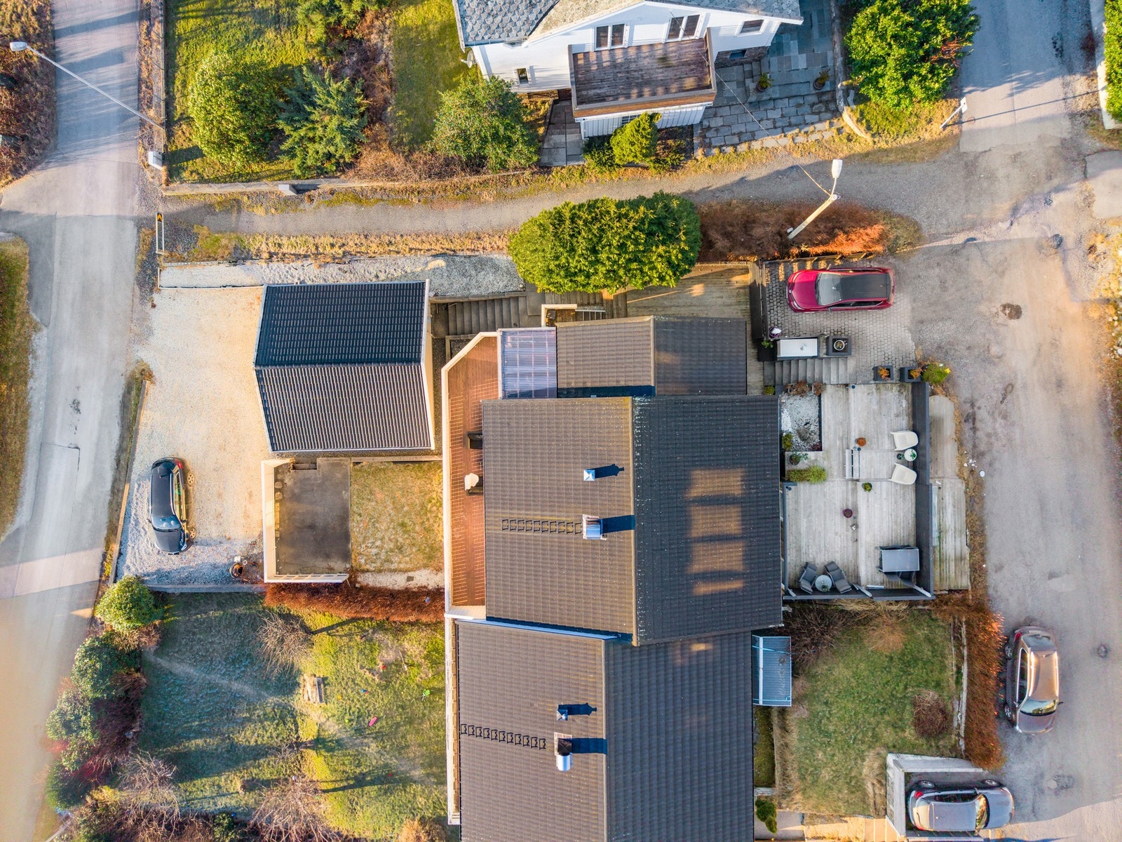 Og sånn ser eiendommen ut fra fugleperspektiv, terrasse, parkeringsplass, veranda, plen, garasje og biloppstillingsplass. Galleribilde
