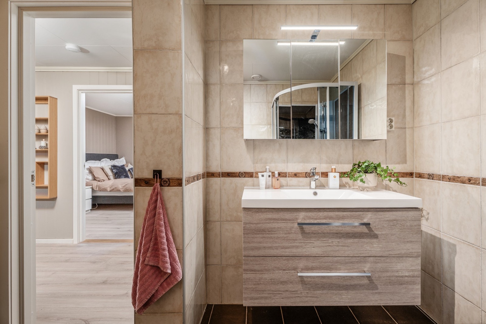 Den lekre servantinnredningen med helstøpt kompositt servantplate har også overskap med speilfronter og god belysning. Galleribilde