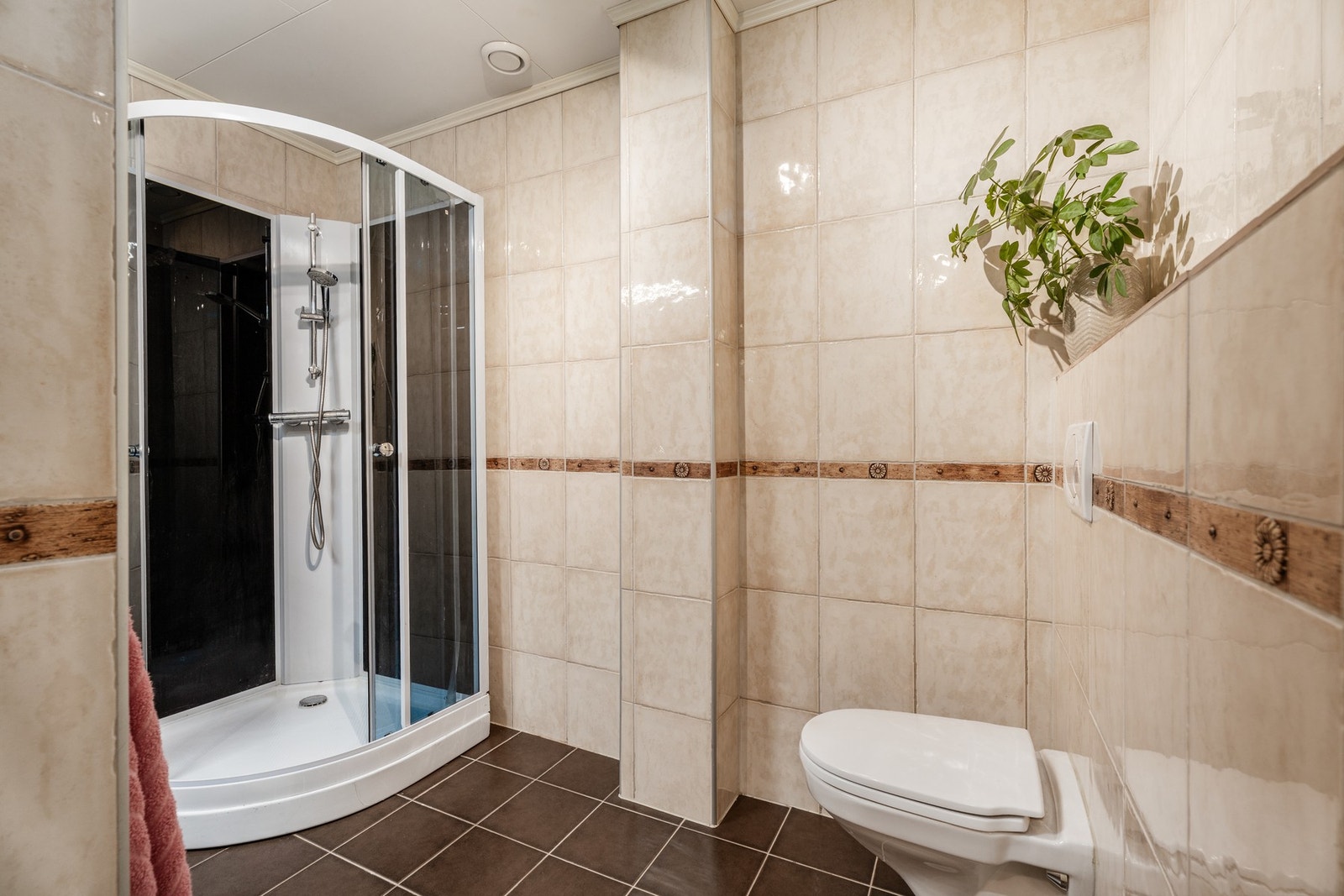 Badet har flislagte overflater og vegghengt toalett Galleribilde