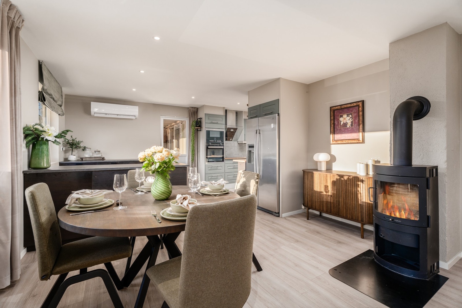 Man har åpen løsning mellom stue og kjøkken og en lun og god vedovn er strategisk plassert i stue. Galleribilde