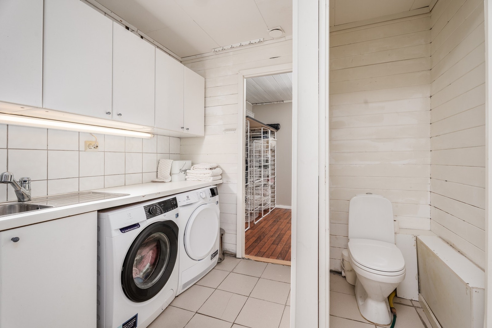 I underetasjen finnes vaskerom med plass for både tørketrommel, vaskemaskin og en god arbeidsbenk. Varmekabler fra 2010 på vaskerommet. Galleribilde