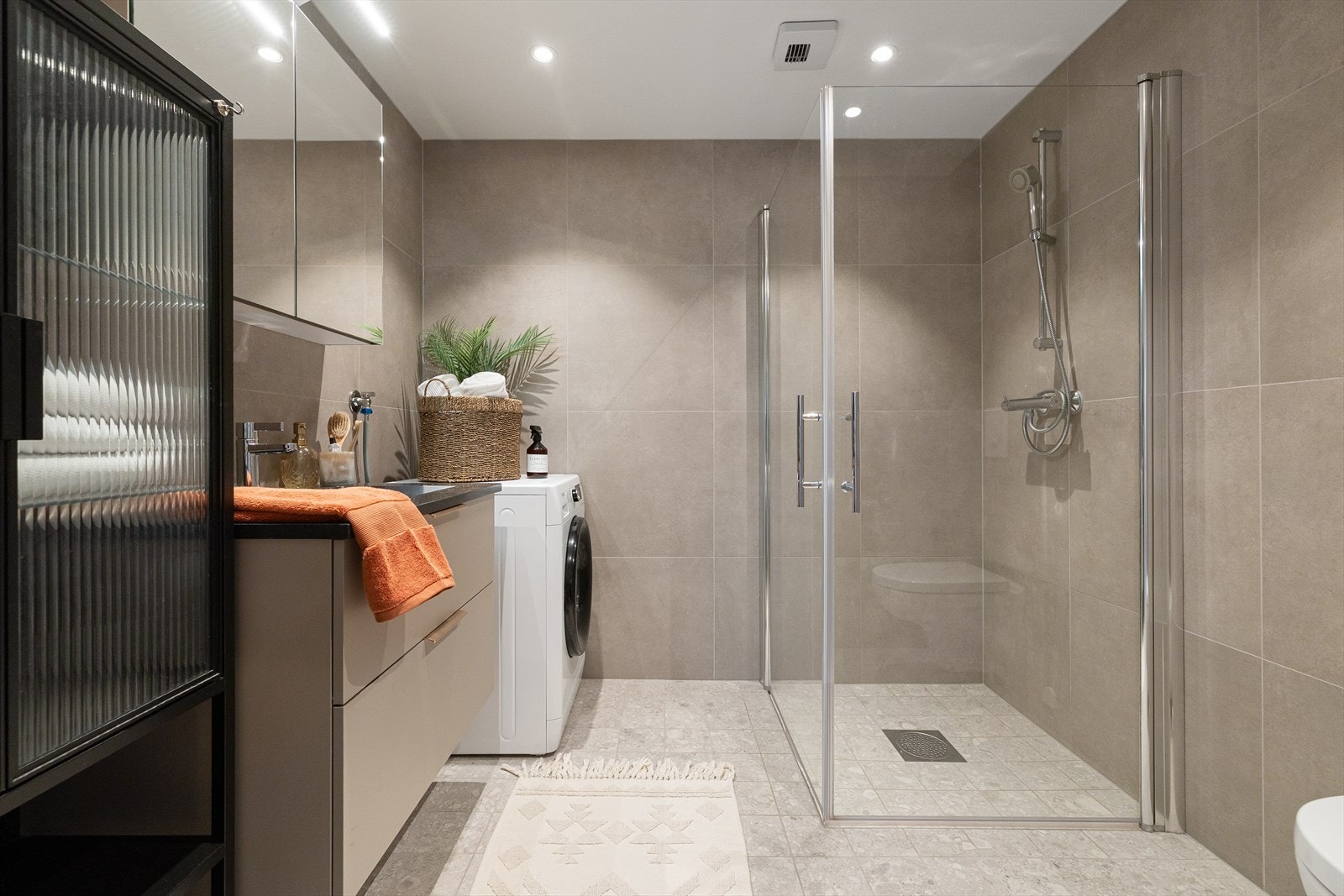 Stort, helfliset bad med varmekabler i gulv, downlights i himling og opplegg for vaskemaskin Galleribilde