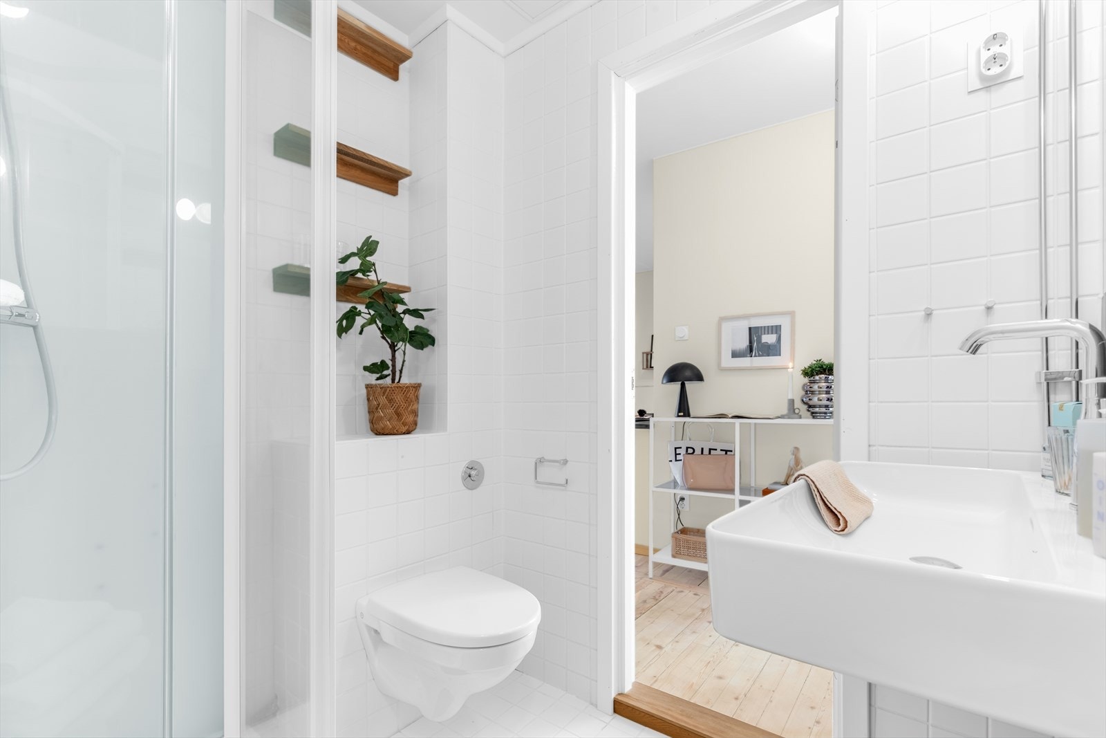 Rommet er innredet med servant, veggmontert WC og dusj - et tidløst og funksjonelt bad som fremstår som godt vedlikeholdt. Galleribilde