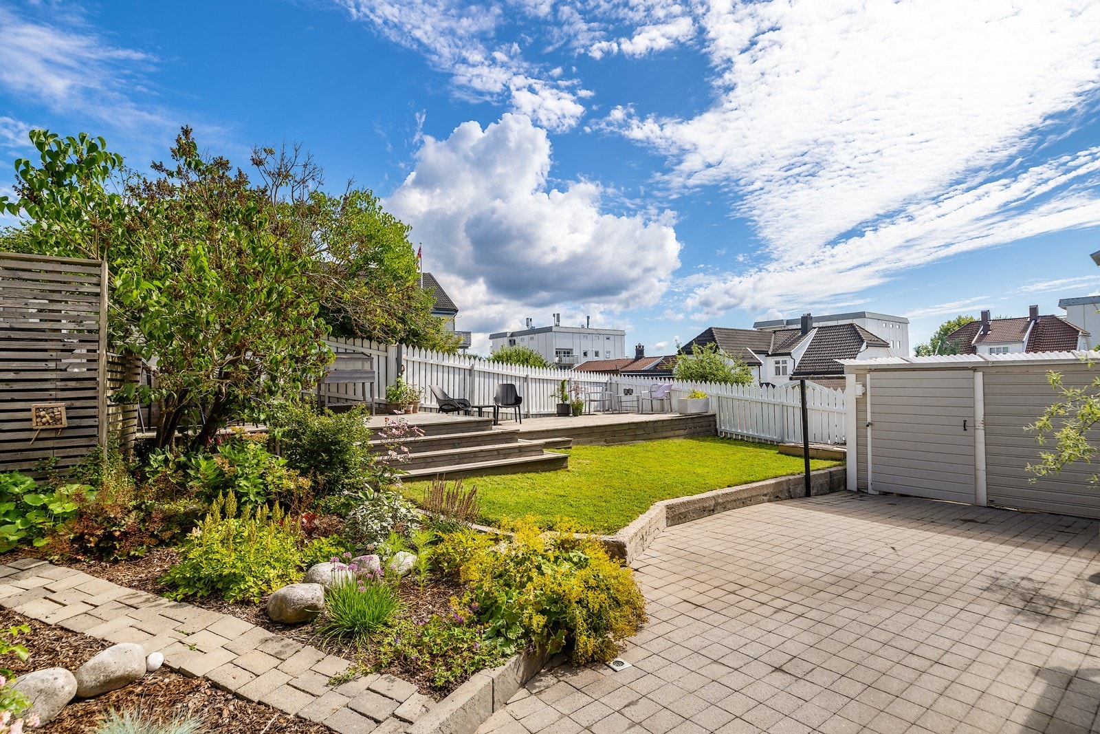 På sommerstid står blomsterbedet i full blomst og skaper en privat oase og nydelig uteområde. Galleribilde