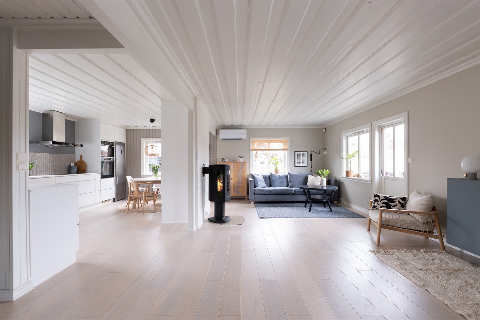 I første etasje er det åpent, luftig og lyst. Stuen og kjøkkenet er sømløst knyttet sammen i en stor sosial sone med gjennomgående dagslys. Galleribilde