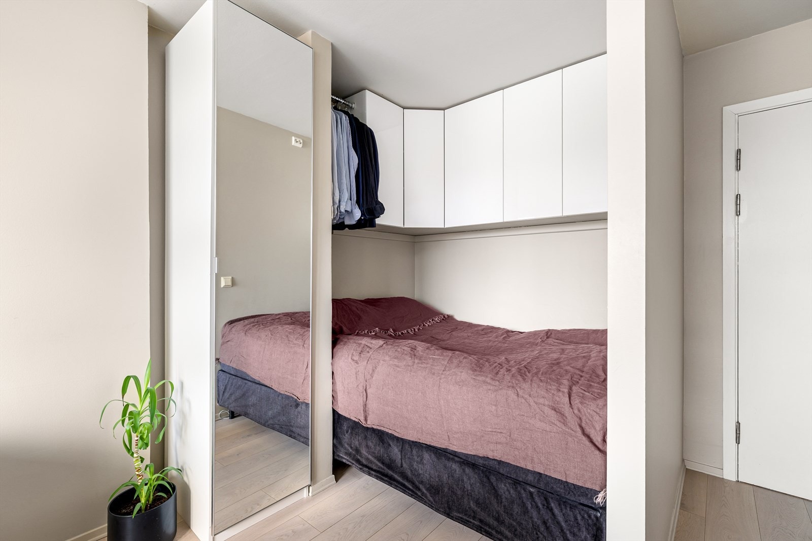 Praktisk sovealkove med plass til dobbeltseng og gode oppbevaringsløsninger i skap Galleribilde