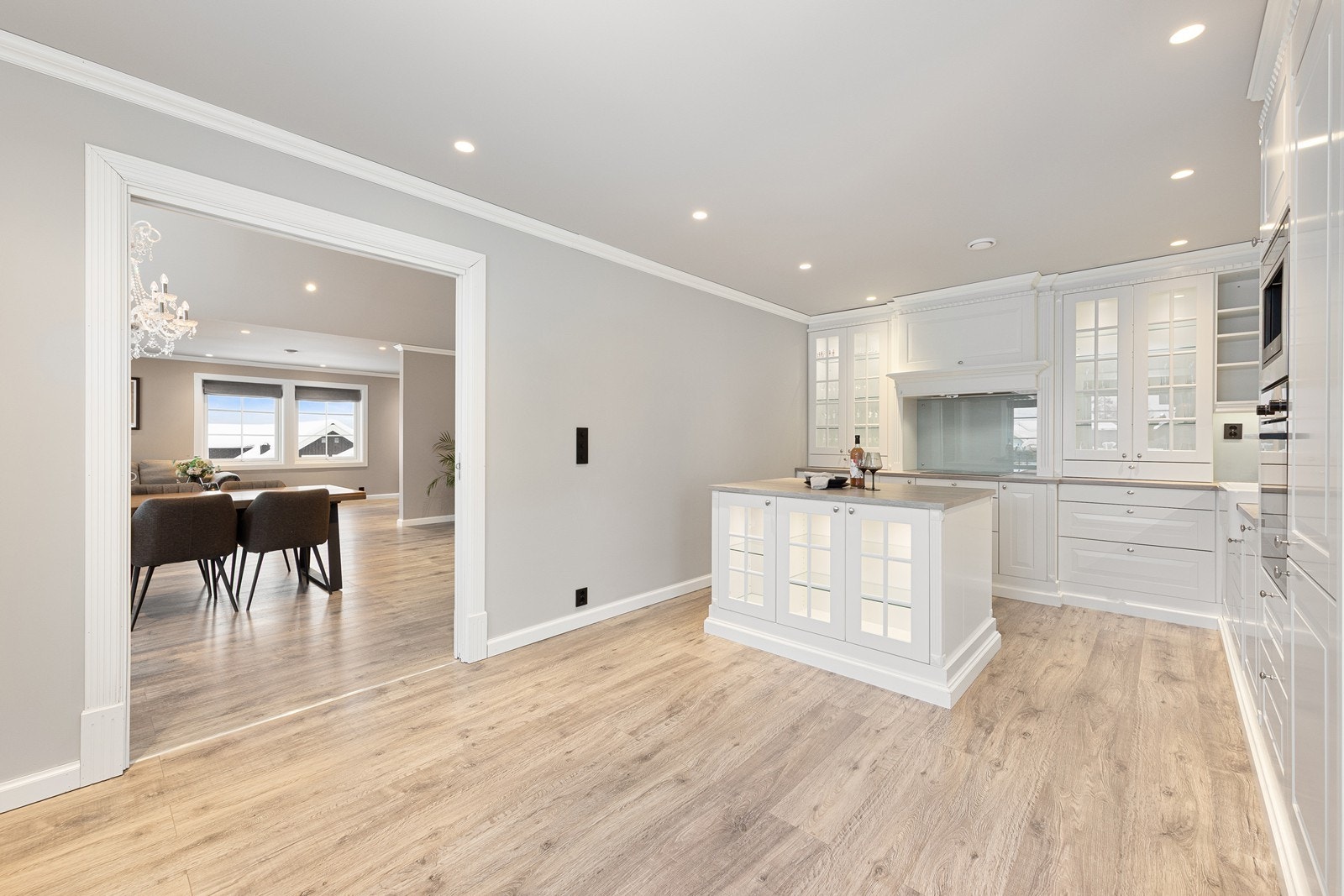 Innredningen inkluderer moderne, integrerte hvitevarer som platetopp, stekeovn, oppvaskmaskin, kjøleskap og kaffemaskin, som bidrar til en praktisk og stilren løsning. Galleribilde