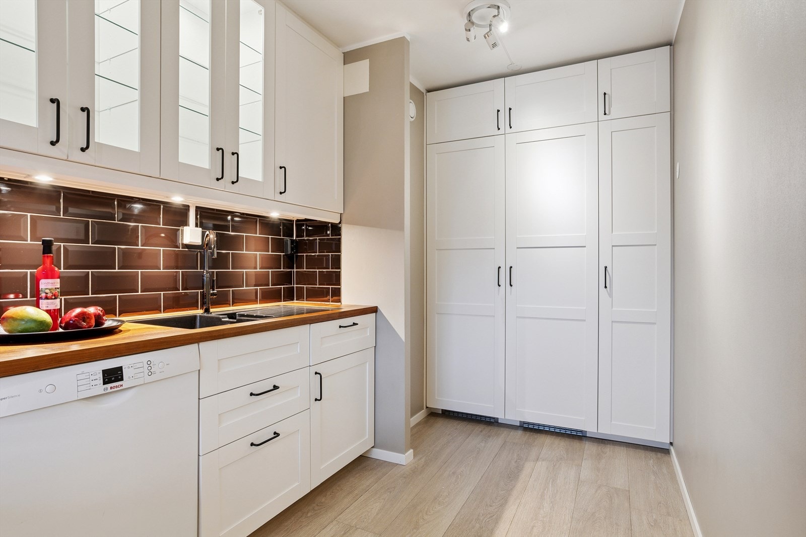 Funksjonell og moderne kjøkkeninnredning med profilerte fronter, både over- og underskap samt høyskap som gir rikelig med oppbevaringsplass. Galleribilde