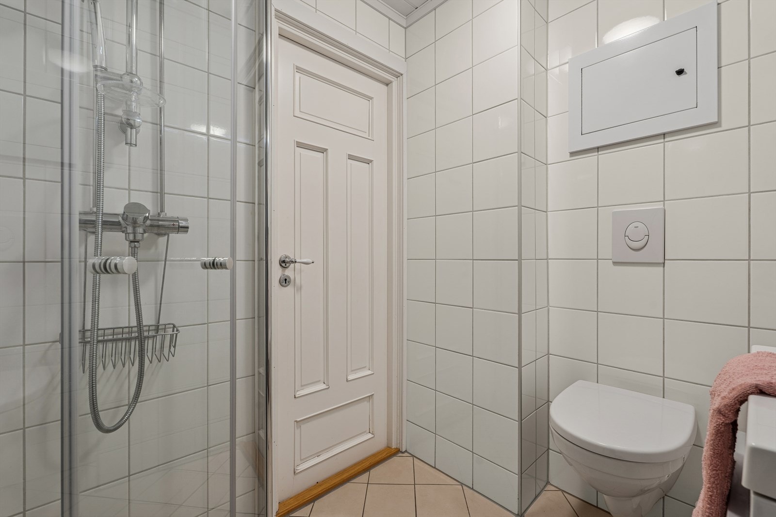 Badet har varmekabler og det er opplegg for vaskemaskin. For øvrig er rommet utstyrt med speilskap, nedfelt servant, veggmontert toalett og dusjhjørne med innfellbare dusjdører. Galleribilde