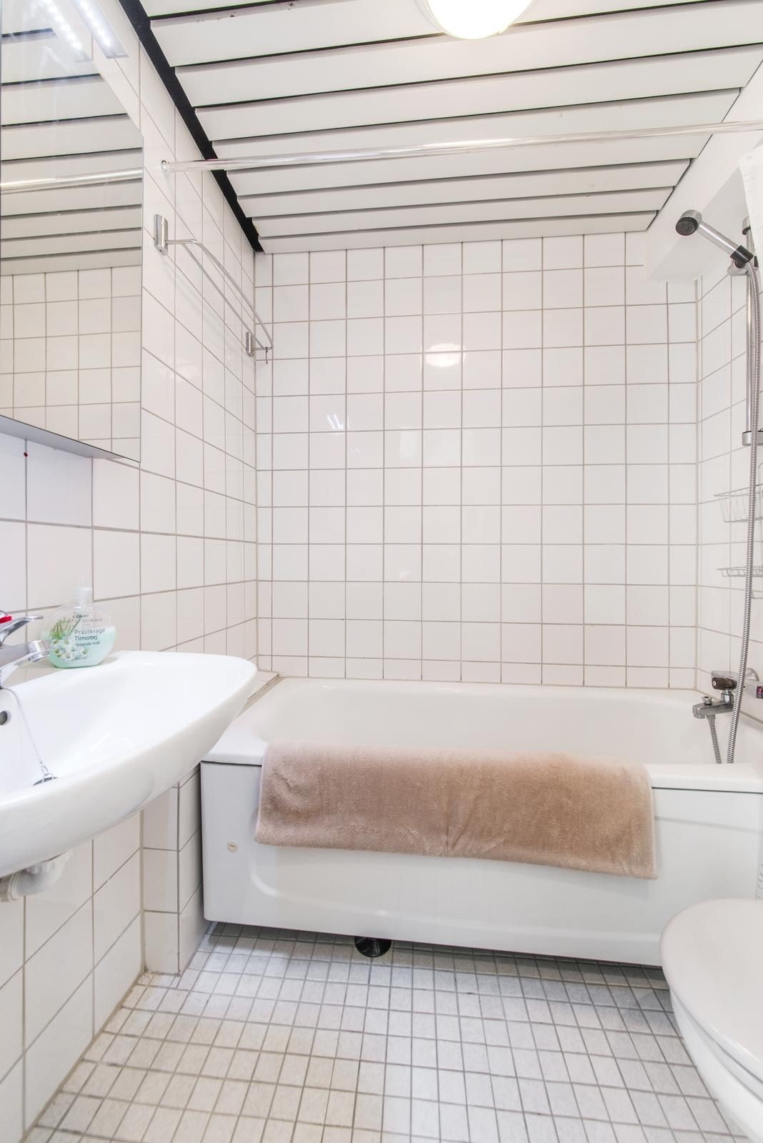 Leilighetens bad ble pusset opp i 2025. Bildet viser det gamle badet. Det er dusj og vaskemaskin nå. Galleribilde