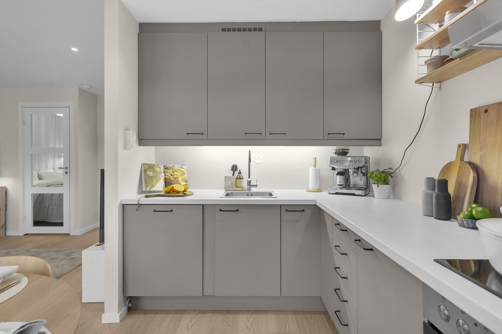 Veggen over benkeplaten er malt med våtromsmaling, og det er montert en praktisk glassplate over koketoppen. Galleribilde