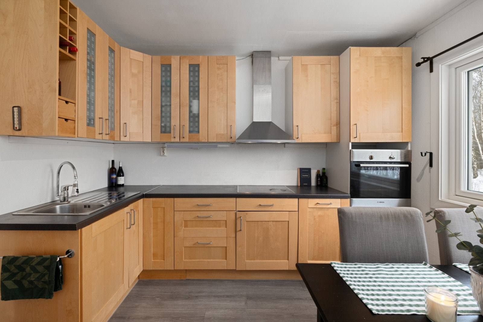 Praktisk kjøkken med god skapplass og spiseplass ved vindu Galleribilde