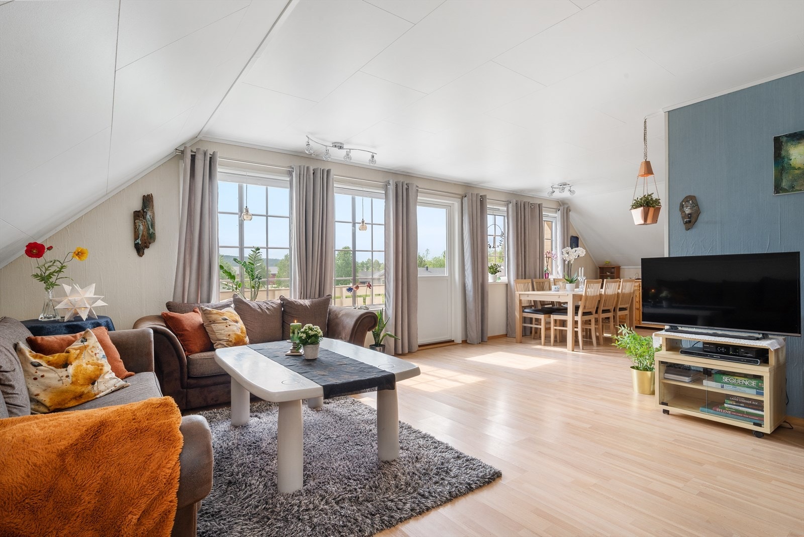 Lys og romslig stue med store vindusflater som gir rikelig med naturlig lys gjennom dagen. Galleribilde