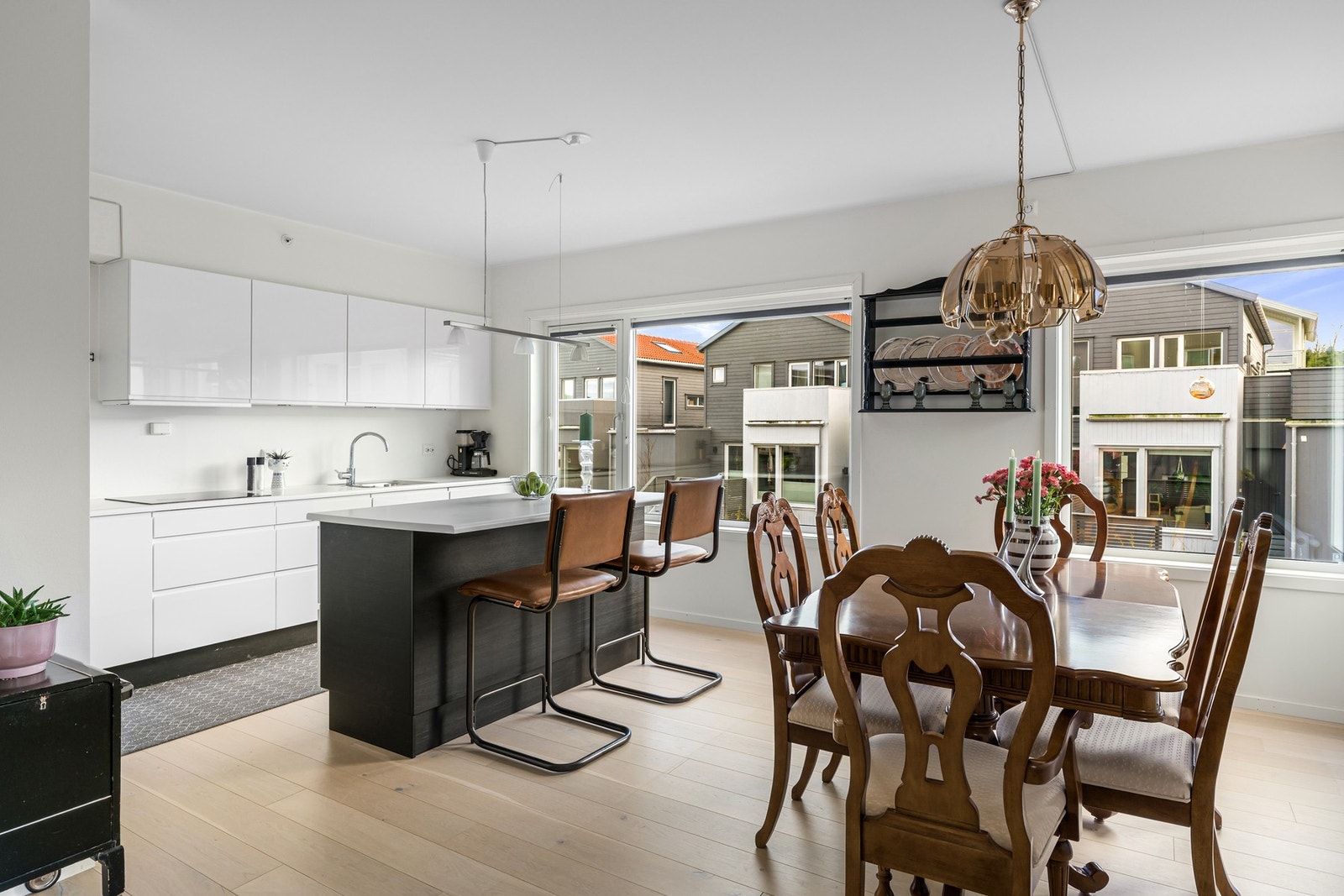 Kjøkkeninnredning med hvite slette fronter og hvit laminert benkeplate. Galleribilde