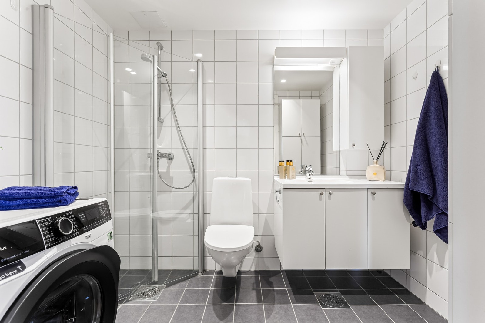 Baderommet er utført med lyse fliser veggene og mørke fliser på gulvet. Baderommet er utstyrt med gulvvarme, samt downlights i himlingen. Galleribilde