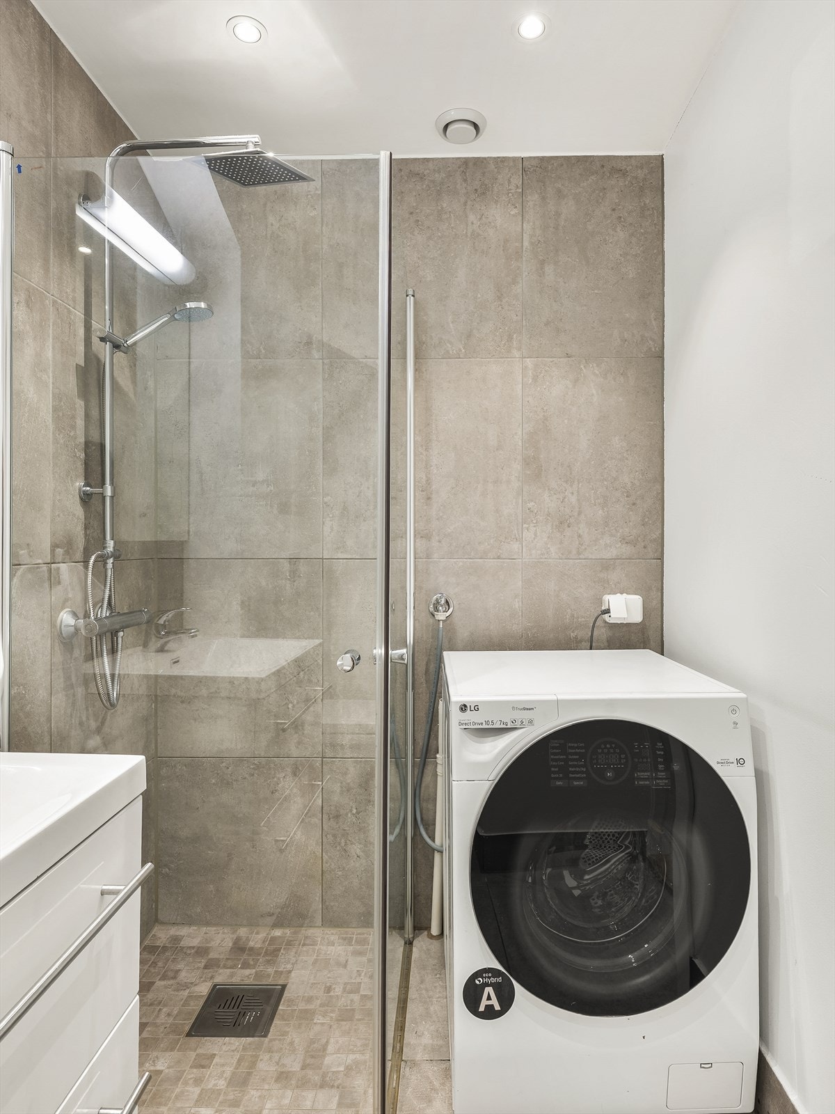 Det er praktisk opplegg for vaskemaskin ved siden av dusjen. Galleribilde