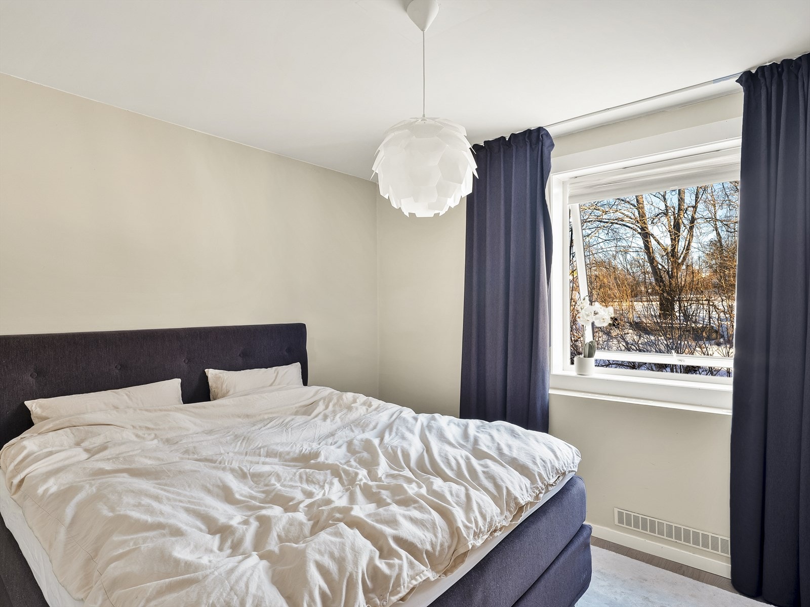 Vinduet vender ut mot et rolig, grønt område uten direkte innsyn. Galleribilde