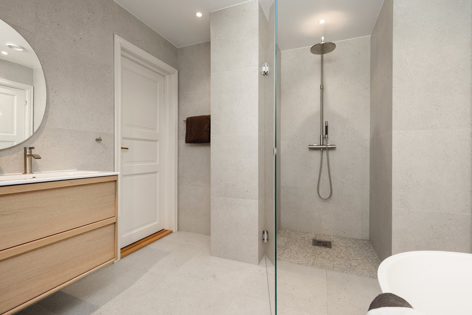 Baderom2: Baderommet består av servantskap med glatte fronter, heldekkende servant, speil med lysarmatur på vegg over servant, veggmontert klosett, frittstående badekar, samt dusjhjørne med glassvegg, sluk, regnfallsdusj, termostatstyrt blandebatteri. Galleribilde