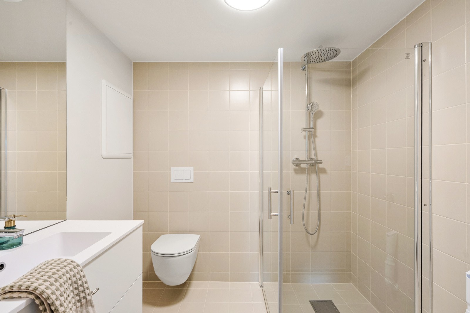 På badet i hybelen er det hvitmalte flater og lyse fliser på veggene, og på gulvet er det lagt matchende fliser over elektrisk gulvvarme. Galleribilde