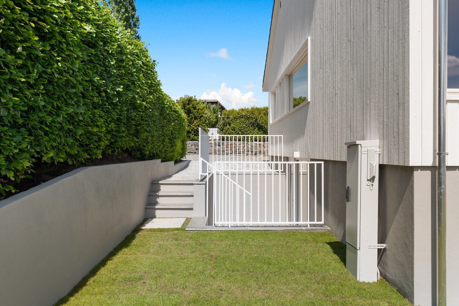 Tomten på 595,6 kvm er lettstelt, solrik og pent opparbeidet med store plenarealer og nyplantet hekk, og mot nord er det en stor, steinbelagt gårdsplass. Galleribilde