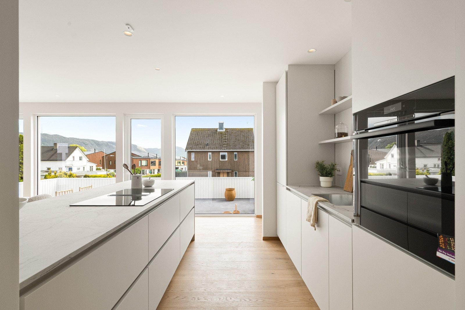 I en stor kjøkkenøy er det en bred induksjonstopp med innebygget kullfilterventilator, og kjøkkenet er videre utstyrt med integrert oppvaskmaskin, kjøleskap og stekeovn. Galleribilde