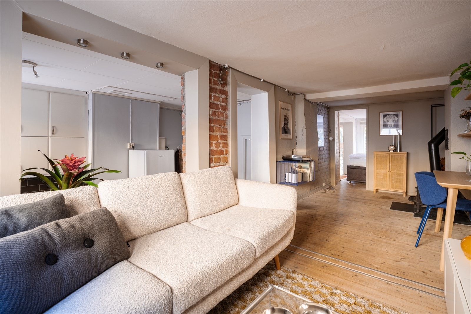 Gulvet er i heltre, som gir en varm og eksklusiv følelse. Mellom stue og kjøkken finner du en stilfull teglesteinsvegg som tilfører leiligheten karakter og et moderne særpreg. Galleribilde