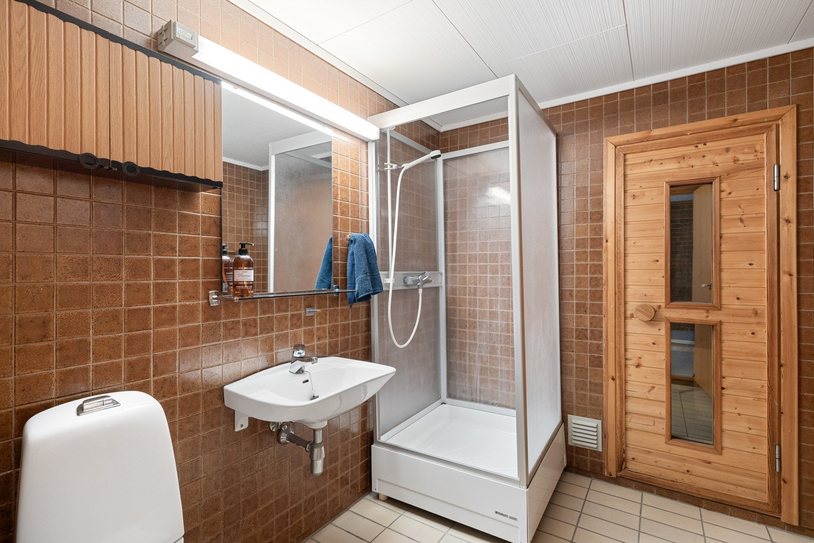 Etasjen har også et romslig bad med fliser på gulv og vegger, dusjløsning, servant og toalett, samt tilknytning til badstue. Galleribilde