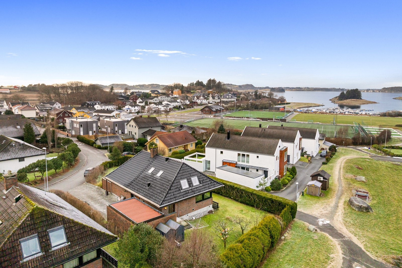 Tomten byr på store plenarealer, beplantning og naturlig skjerming som gir både privatliv og en lun ramme rundt eiendommen. Galleribilde