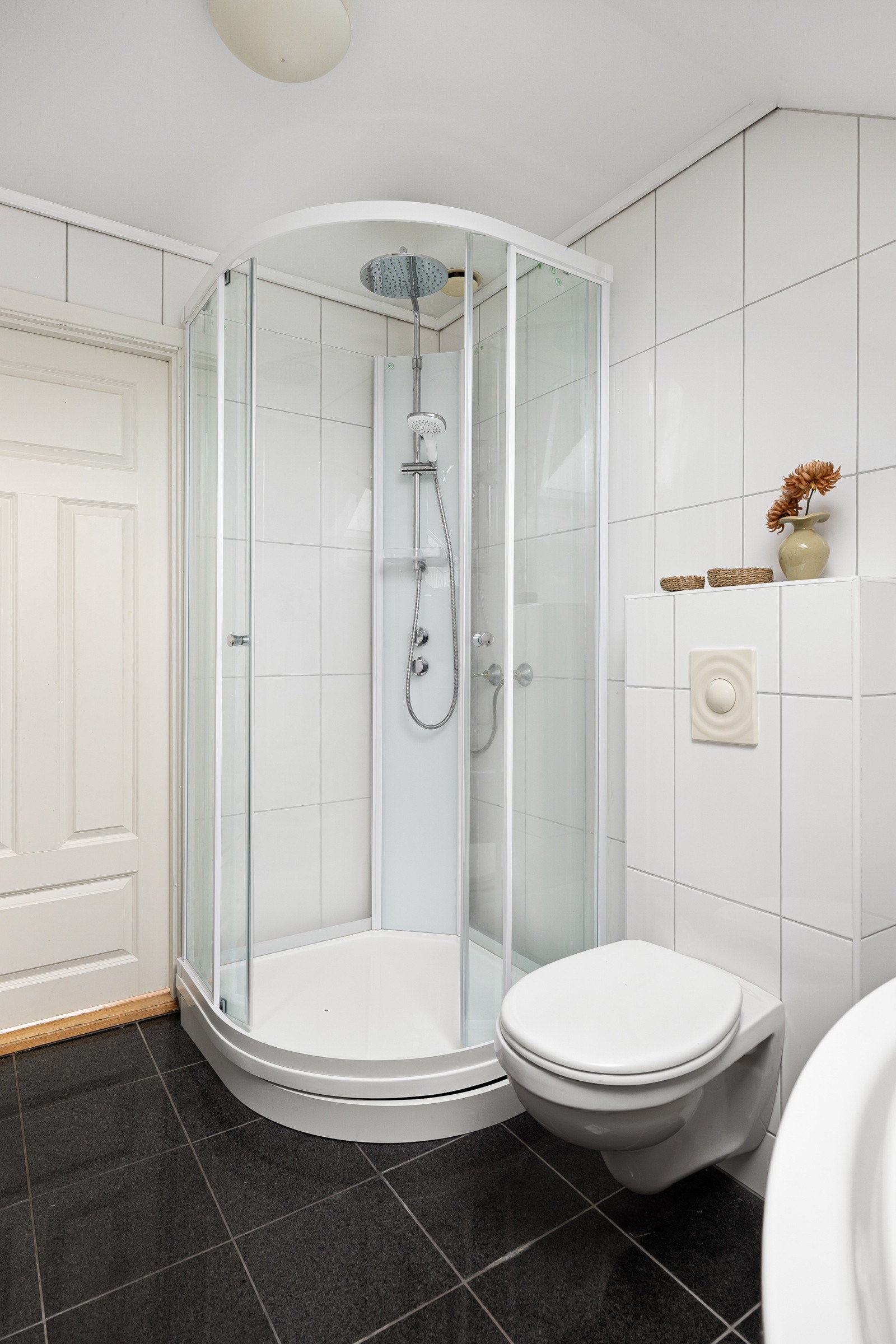 Badet har flislagte flater, dusjkabinett, servant og toalett, og gir god kapasitet for en aktiv familiehverdag. Galleribilde