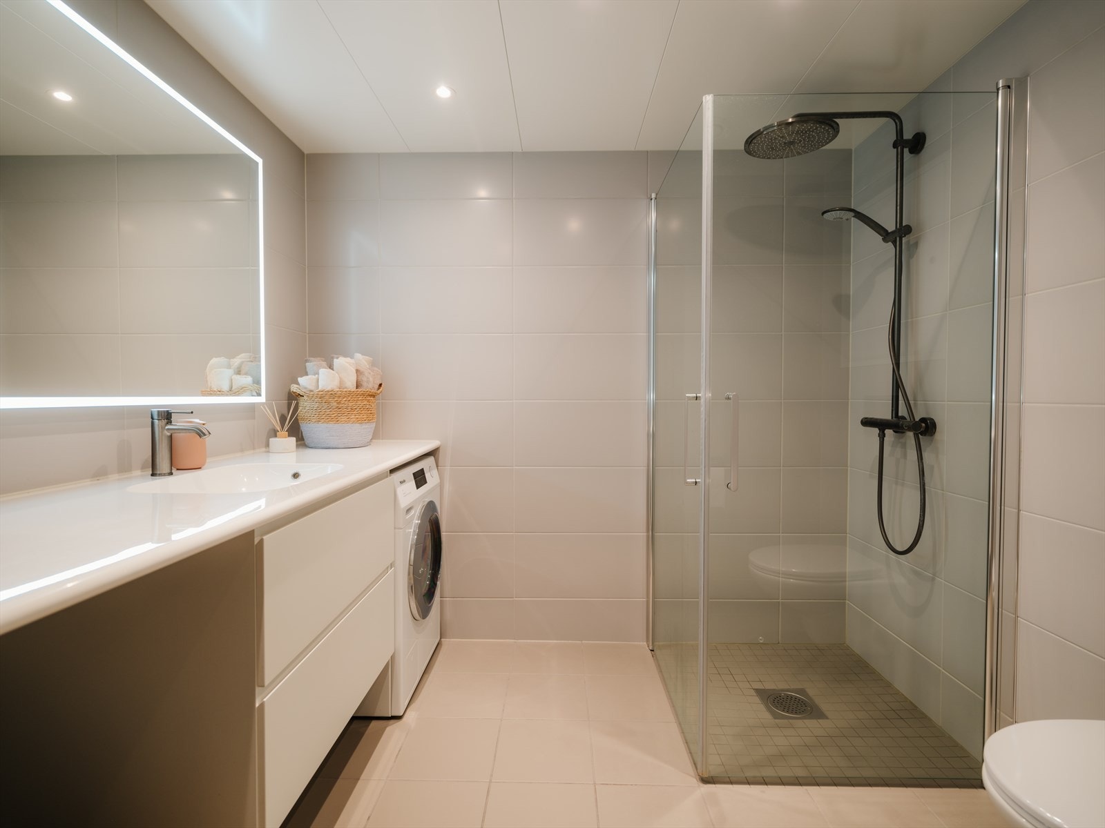 Romslig, helfliset bad med elekektriske varmekabler i gulv og downlights i himling. Opplegg og plass for vaskemaskin Galleribilde