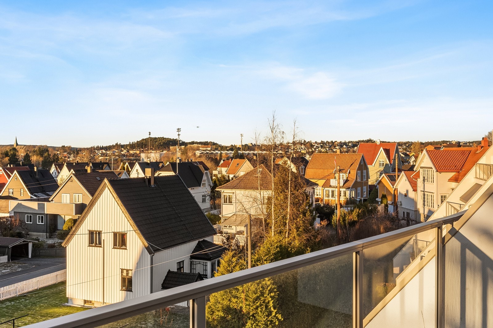 Balkongen har glassrekkverk som gir et klart utsyn over nabolaget. Galleribilde